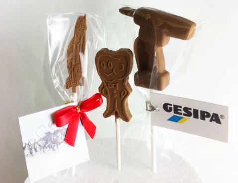 Schoko-Lolly mit Logo – drei Lollys aus Vollmilchschokolade in eigener Form (Auto, Maskottchen, Akkuschrauber) am Stiel im Klarsichtbeutel