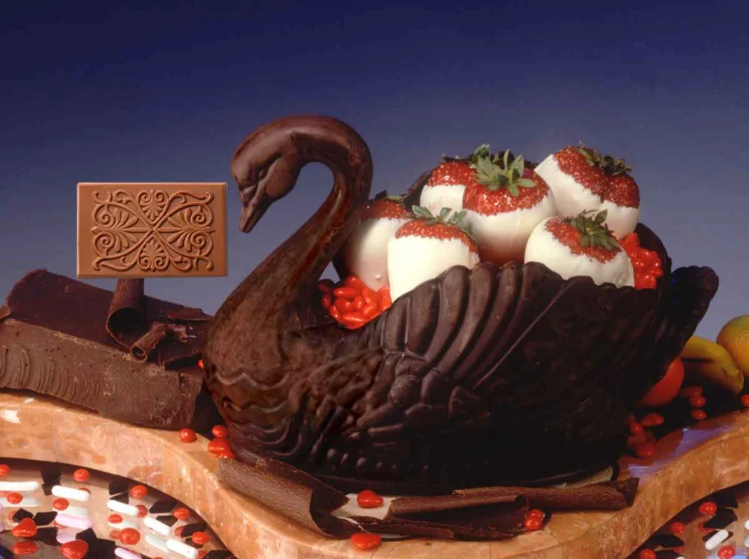 Schwan aus dunkler Schokolade mit Erdbeeren und geprägter Schokoladentafel – Kunstwerk aus Schokolade
